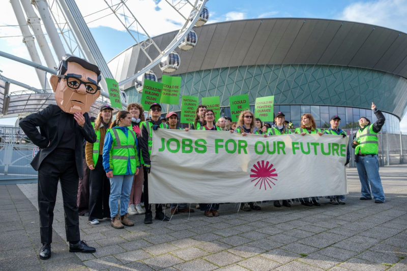 Young people hand CVs to a cardboard Burnham in climate jobs protest